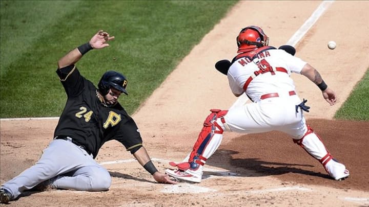 Oct 4, 2013; St. Louis, MO, USA; Pittsburgh Pirates third baseman Pedro Alvarez (24) scores a run past the throw to St. Louis Cardinals catcher Yadier Molina (4) in the second inning in game two of the National League divisional series playoff baseball game at Busch Stadium. Mandatory Credit: Jasen Vinlove-USA TODAY Sports