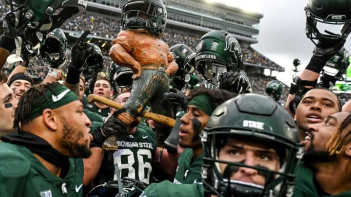 Michigan State celebrates with the Paul Bunyan Trophy after beating Michigan on Saturday, Oct. 30, 2021, at Spartan Stadium in East Lansing.