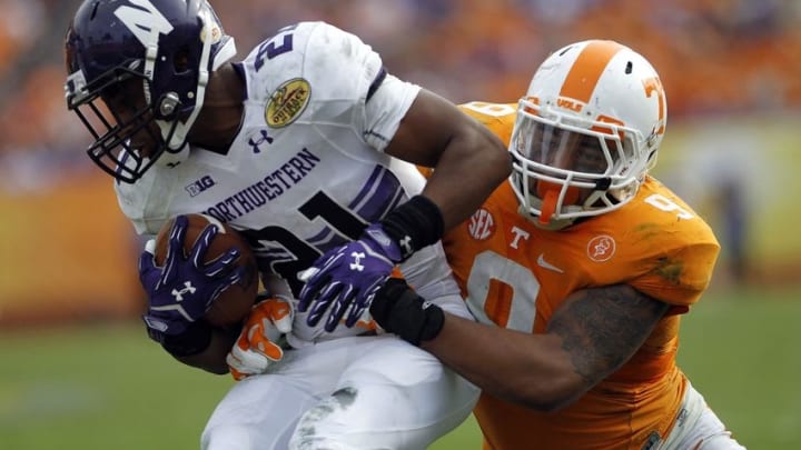 Jan 1, 2016; Tampa, FL, USA; Northwestern Wildcats running back Justin Jackson (21) runs the ball against Tennessee Volunteers defensive back Derek Barnett (9) in the second half at the 2016 Outback Bowl at Raymond James Stadium. Tennessee defeated Northwestern 45-6. Mandatory Credit: Mark Zerof-USA TODAY Sports