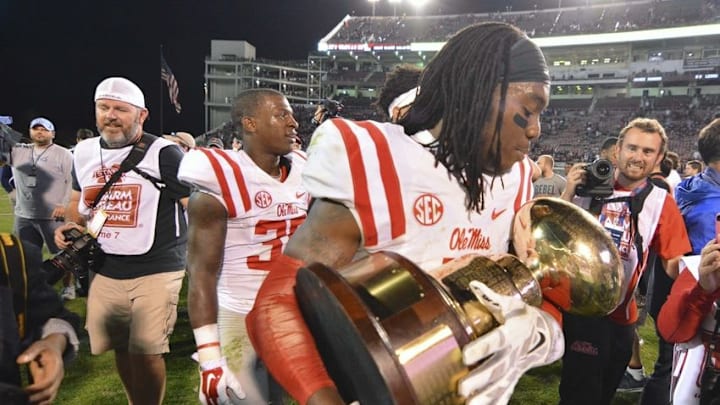 Nov 28, 2015; Starkville, MS, USA; Mississippi Rebels defensive back Trae Elston (7) celebrates with the Egg Bowl trophy after the game against the Mississippi State Bulldogs at Davis Wade Stadium. Mississippi won 38-27. Mandatory Credit: Matt Bush-USA TODAY Sports