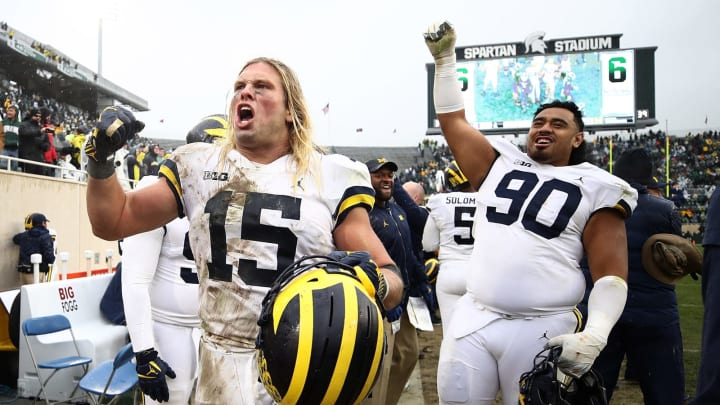EAST LANSING, MI – OCTOBER 20: Chase Winovich #15 and Bryan Mone #90 of the Michigan Wolverines celebrate on the sideline as the clock winded down on a 21-7 win over the Michigan State Spartans at Spartan Stadium on October 20, 2018 in East Lansing, Michigan. (Photo by Gregory Shamus/Getty Images)