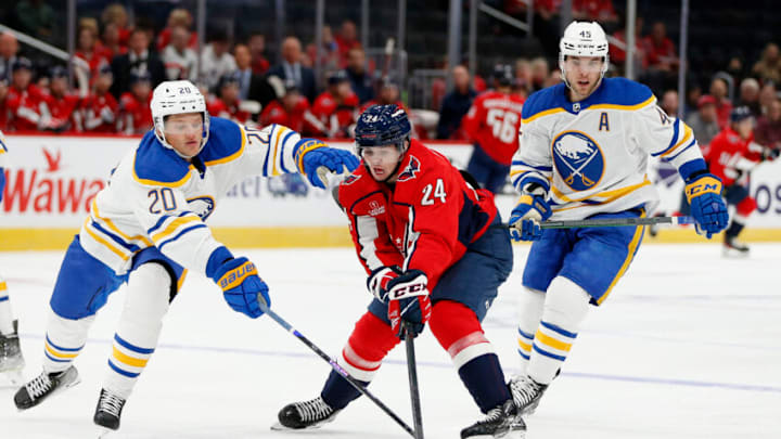 Sep 25, 2022; Washington, District of Columbia, USA; Washington Capitals center Connor McMichael (24) battles for the puck with Buffalo Sabres defenseman Lawrence Pilut (20) during the first period at Capital One Arena. Mandatory Credit: Amber Searls-USA TODAY Sports