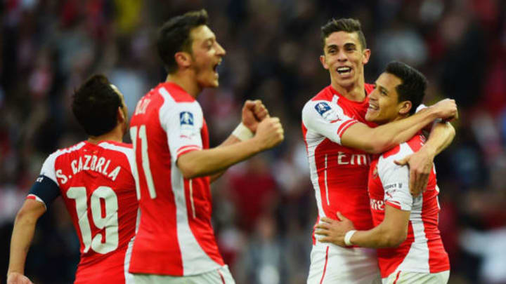 LONDON, ENGLAND – APRIL 18: Alexis Sanchez of Arsenal (R) celebrates with Santi Cazorla (L), Mesut Oezil (2L) and Gabriel (2R) as he scores their second goal during the FA Cup Semi Final between Arsenal and Reading at Wembley Stadium on April 18, 2015 in London, England. (Photo by Mike Hewitt/Getty Images)