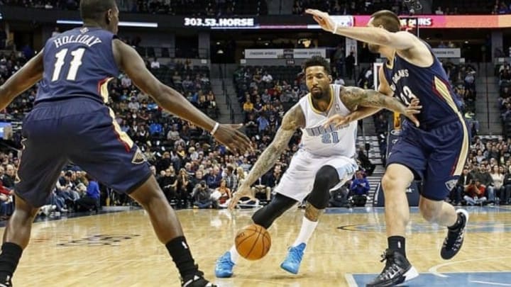Dec 15, 2013; Denver, CO, USA; Denver Nuggets shooting guard Wilson Chandler (21) dribbles the ball around New Orleans Pelicans power forward Ryan Anderson (33) and point guard Jrue Holiday (11) in the first quarter at the Pepsi Center. Mandatory Credit: Isaiah J. Downing-USA TODAY Sports