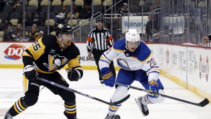 Oct 7, 2022; Pittsburgh, Pennsylvania, USA; Pittsburgh Penguins center Ryan Poehling (25) and Buffalo Sabres defenseman Lawrence Pilut (20) chase the puck during the third period at PPG Paints Arena. The Penguins won 7-1. Mandatory Credit: Charles LeClaire-USA TODAY Sports