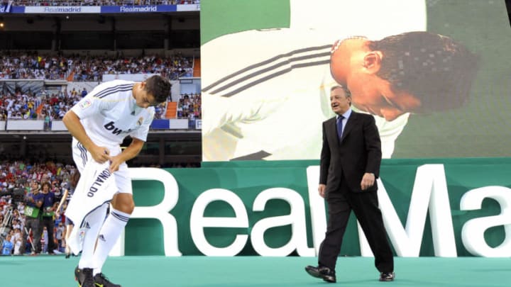 Real Madrid’s new player Portuguese Cristiano Ronaldo (L) signs his new number 9 jersey next to Real Madrid president Florentino Perez (R) during his official presentation at the Santiago Bernabeu stadium in Madrid on July 6, 2009. Real acquired the 24-year-old Portuguese striker from Manchester United last month on a six-year deal worth 94 million euros (131 million dollars) and Spanish media reports that he will be paid 13 million euros each season. AFP PHOTO / DANI POZO (Photo credit should read Dani Pozo/AFP/Getty Images)