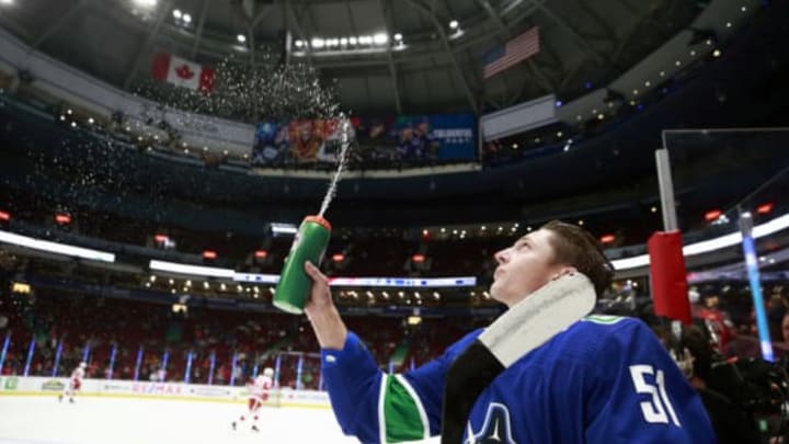 VANCOUVER, BC – OCTOBER 15: Troy Stecher #51 of the Vancouver Canucks sprays water in the air during their NHL game against the Detroit Red Wings at Rogers Arena October 15, 2019 in Vancouver, British Columbia, Canada. (Photo by Jeff Vinnick/NHLI via Getty Images)”n