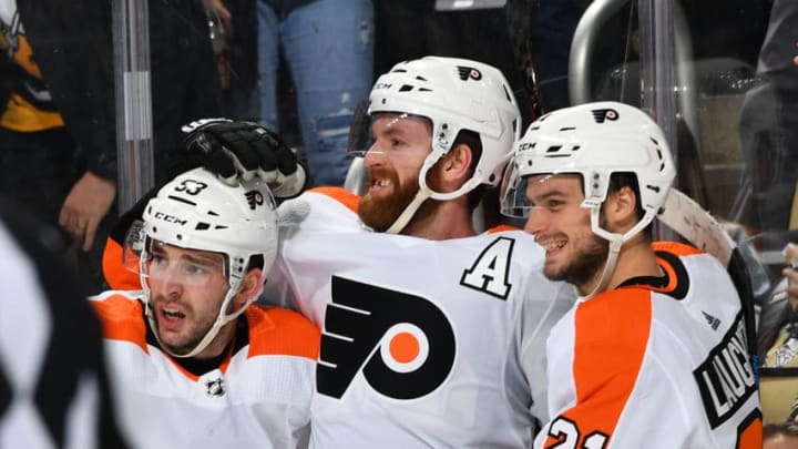 PITTSBURGH, PA - MARCH 17: Sean Couturier #14 of the Philadelphia Flyers celebrates his overtime goal with Shayne Gostisbehere #53 and Scott Laughton #21 against the Pittsburgh Penguins at PPG Paints Arena on March 17, 2019 in Pittsburgh, Pennsylvania. (Photo by Joe Sargent/NHLI via Getty Images)