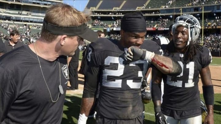 Sep 15, 2013; Oakland, CA, USA; Oakland Raiders cornerback Tracy Porter (23) shows an abrasion to defensive coordinator Jason Tarver (left) and cornerback Mike Jenkins (21) after the game against the Jacksonville Jaguars at O.co Coliseum. The Raiders defeated the Jaguars 19-9. Mandatory Credit: Kirby Lee-USA TODAY Sports