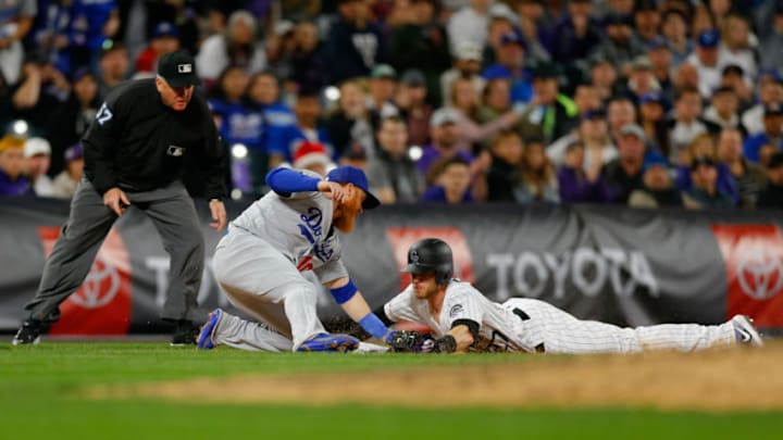 DENVER, CO - APRIL 7: Third baseman Justin Turner #10 of the Los Angeles Dodgers applies the tag on Trevor Story #27 of the Colorado Rockies who is caught trying to advance on a base hit as third base umpire Mike Everitt looks on for the final out of the sixth inning at Coors Field on April 7, 2019 in Denver, Colorado. The Dodgers defeated the Rockies 12-6 to sweep the three game series.(Photo by Justin Edmonds/Getty Images)