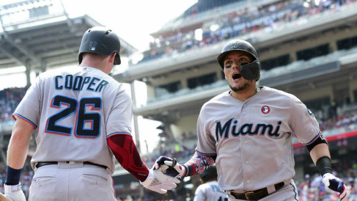 WASHINGTON, DC - JULY 04: Miguel Rojas #19 of the Miami Marlins celebrates with teammate Garrett Cooper #26 after hitting a solo home run in the first inning against the Washington Nationals at Nationals Park on July 4, 2019 in Washington, DC. (Photo by Patrick McDermott/Getty Images)