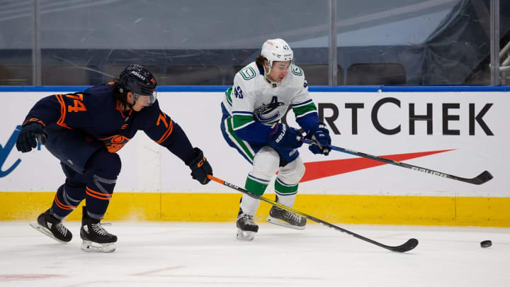 EDMONTON, AB – MAY 15: Ethan Bear #74 of the Edmonton Oilers battles for the puck against Quinn Hughes #43 of the Vancouver Canucks at Rogers Place on May 15, 2021 in Edmonton, Canada. (Photo by Codie McLachlan/Getty Images)