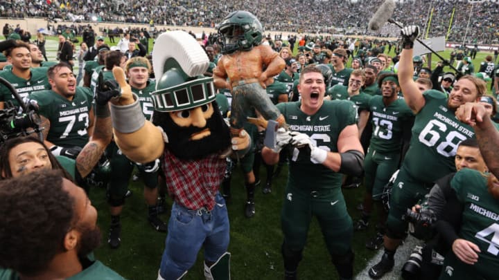EAST LANSING, MICHIGAN - OCTOBER 30: AJ Arcuri #76 of the Michigan State Spartans celebrates with the Paul Bunyan trophy with Sparty the Michigan State Spartans mascot after defeating Michigan Wolverines 37-33 at Spartan Stadium on October 30, 2021 in East Lansing, Michigan. (Photo by Gregory Shamus/Getty Images)