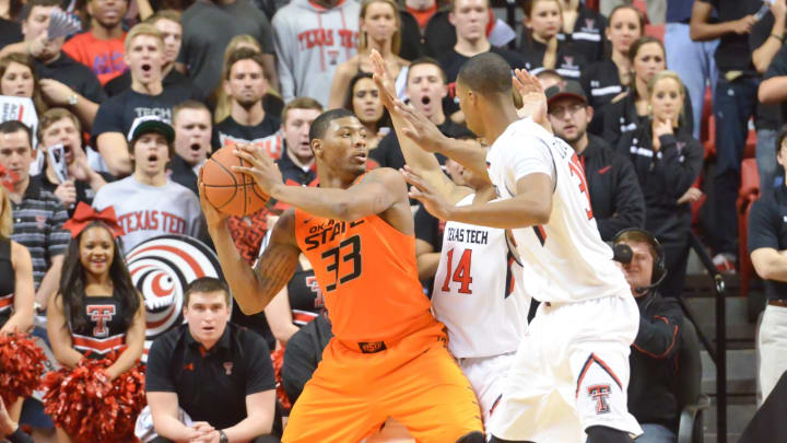Marcus Smart #33 of the Oklahoma State Cowboys is guarded by Robert Turner #14 and Jaye Crockett #30 of the Texas Tech Red Raiders.(Photo by John Weast/Getty Images)