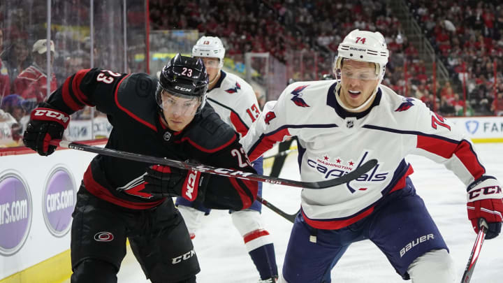 RALEIGH, NC – APRIL 18: Carolina Hurricanes left wing Brock McGinn (23) and Washington Capitals defenseman John Carlson (74) chase a puck along the boards during a game between the Carolina Hurricanes and the Washington Capitals on April 18, 2019, at the PNC Arena in Raleigh, NC. (Photo by Greg Thompson/Icon Sportswire via Getty Images)