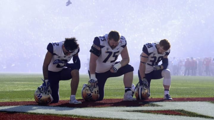 PASADENA, CA - JANUARY 01: Aaron Fuller #2 of the Washington Huskies, Jesse Sosebee #75 of the Washington Huskies and Zechariah Brown #38 of the Washington Huskies take a knee during the National Anthem during the Rose Bowl Game presented by Northwestern Mutual at the Rose Bowl on January 1, 2019 in Pasadena, California. (Photo by Kevork Djansezian/Getty Images)