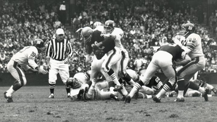 CLEVELAND – OCTOBER 27: Jim Brown #32 of the Cleveland Browns fights off Sam Huff #70 of the New York Giants as Jimmy Patton #20 pursues the play during the game against the New York Giants at Cleveland Stadium on October 27, 1963 in Cleveland, Ohio. (Photo by Robert Riger/Getty Images)