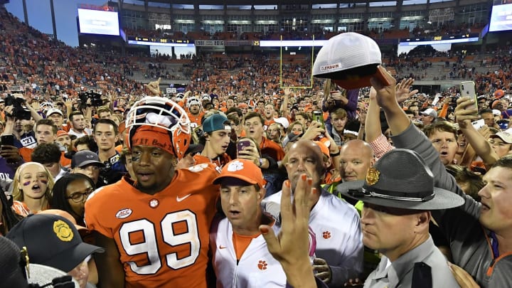 CLEMSON, SC – OCTOBER 20: Defensive end Clelin Ferrell #99 and head coach Dabo Swinney of the Clemson Tigers embrace at midfield while surrounded by fans singing the Clemson Alma Mater during the football game at Clemson Memorial Stadium on October 20, 2018 in Clemson, South Carolina. (Photo by Mike Comer/Getty Images)
