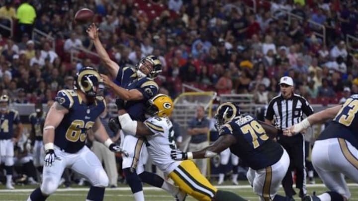 Aug 16, 2014; St. Louis, MO, USA; St. Louis Rams quarterback Sam Bradford (8) is hit by Green Bay Packers defensive end Julius Peppers (56) while attempting a pass during the first half at Edward Jones Dome. Mandatory Credit: Jasen Vinlove-USA TODAY Sports