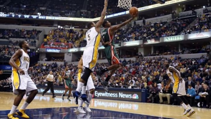 Nov 4, 2014; Indianapolis, IN, USA; Milwaukee Bucks guard Brandon Knight (11) lays the ball in against Indiana Pacers forward Lavoy Allen (5) at Bankers Life Fieldhouse. Mandatory Credit: Brian Spurlock-USA TODAY Sports