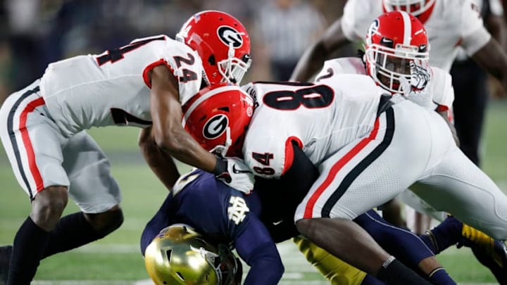 SOUTH BEND, IN - SEPTEMBER 09: Walter Grant #84 and Dominick Sanders #24 of the Georgia Bulldogs make a tackle against the Notre Dame Fighting Irish in the first quarter of a game at Notre Dame Stadium on September 9, 2017 in South Bend, Indiana. (Photo by Joe Robbins/Getty Images)