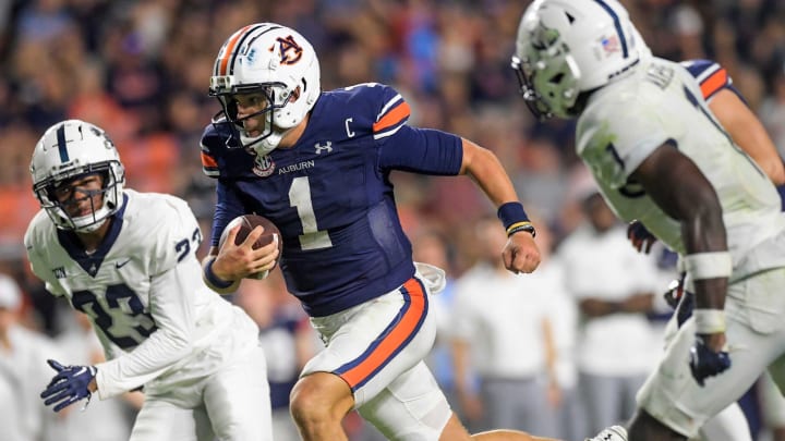 Auburn Tigers quarterback Payton Thorne (1) splts the Samford defenders, defensive back Devin Smith (23) and defensive back Kourtlan Marsh (1) as he carries for a touchdown during second half action in the AU vs. Samford game at Jordan-Hare Stadium in the AU campus in Auburn, Ala., on Saturday September 16, 2023.