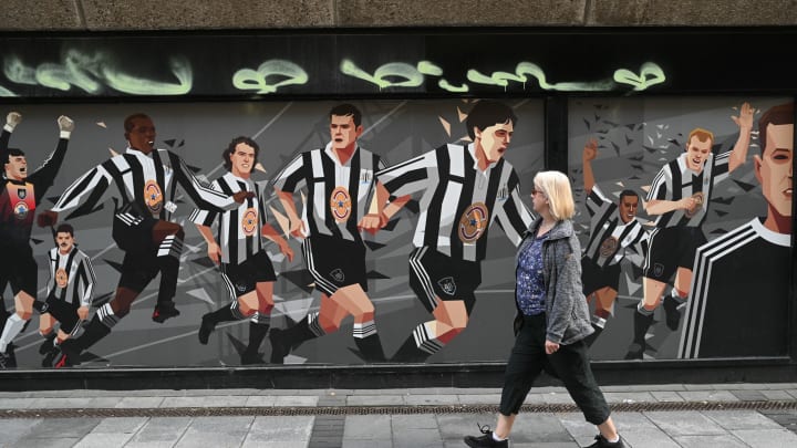 A pedestrian passes a Newcastle United football club-themed mural in Newcastle upon Tyne in northeast England on October 8, 2021. – A Saudi-led consortium completed its takeover of Premier League club Newcastle United on October 7 despite warnings from Amnesty International that the deal represented “sportswashing” of the Gulf kingdom’s human rights record. (Photo by Oli SCARFF / AFP) (Photo by OLI SCARFF/AFP via Getty Images)