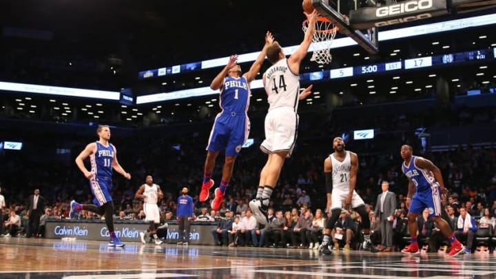 Mar 15, 2016; Brooklyn, NY, USA; Brooklyn Nets guard Bojan Bogdanovic (44) reaches for the net in front of Philadelphia 76ers guard Ish Smith (1) during the first quarter at Barclays Center. Mandatory Credit: Anthony Gruppuso-USA TODAY Sports