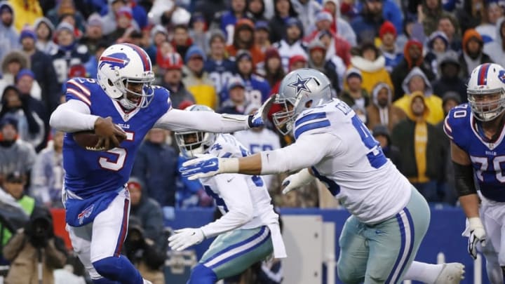 Dec 27, 2015; Orchard Park, NY, USA; Buffalo Bills quarterback Tyrod Taylor (5) stiff arms Dallas Cowboys defensive tackle Tyrone Crawford (98) on a run during the second half at Ralph Wilson Stadium. The Bills defeat Cowboys 16-6. Mandatory Credit: Kevin Hoffman-USA TODAY Sports