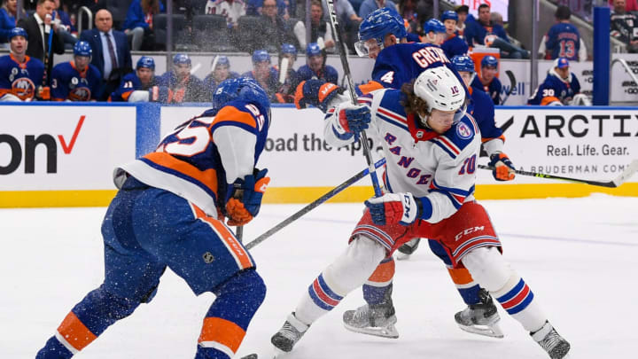 Apr 21, 2022; Elmont, New York, USA; New York Islanders defenseman Sebastian Aho (25) and New York Islanders defenseman Andy Greene (4) defend against New York Rangers left wing Artemi Panarin (10) during the first period at UBS Arena. Mandatory Credit: Dennis Schneidler-USA TODAY Sports