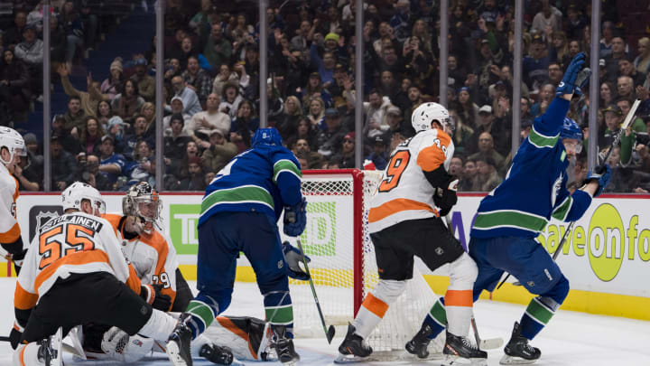 Feb 18, 2023; Vancouver, British Columbia, CAN; Philadelphia Flyers defenseman Rasmus Ristolainen (55) and goalie Carter Hart (79) and forward Noah Cates (49) and Vancouver Canucks forward J.T. Miller (9) watch as forward Phillip Di Giuseppe (34) celebrates his goal in the third period at Rogers Arena. Canucks won 6-2. Mandatory Credit: Bob Frid-USA TODAY Sports