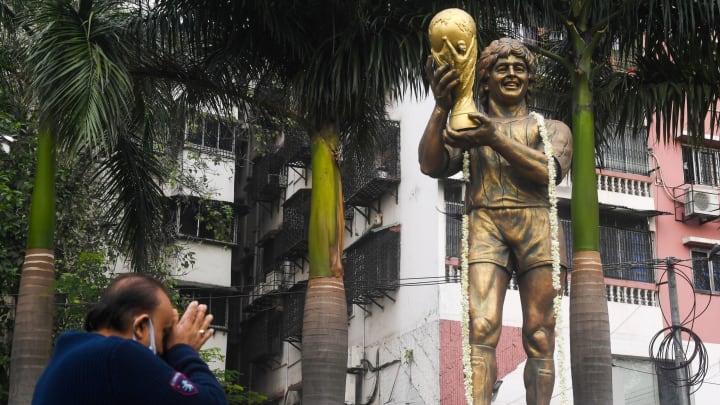 A man pays his tribute in front of a statue of Argentina’s player Diego Maradona in Kolkata on November 26, 2020. – Millions of fans paid tribute and Argentina was plunged into mourning on November 25 as Maradona, one of the greatest footballers of all time, died aged 60 after years of drug and alcohol problems. (Photo by Dibyangshu SARKAR / AFP) (Photo by DIBYANGSHU SARKAR/AFP via Getty Images)