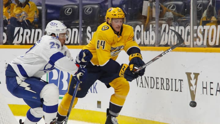 NASHVILLE, TENNESSEE - APRIL 13: Tanner Jeannot #84 of the Nashville Predators skates against Ryan McDonagh #27 of the Tampa Bay Lightning during the third period at Bridgestone Arena on April 13, 2021 in Nashville, Tennessee. (Photo by Frederick Breedon/Getty Images)