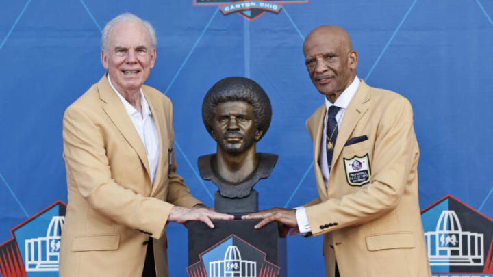 CANTON, OHIO – AUGUST 08: Drew Pearson (R), a member of the Pro Football Hall of Fame Class of 2021, and his presenter Roger Staubach, pose with the bust during the induction ceremony at Tom Benson Hall Of Fame Stadium on August 8, 2021, in Canton, Ohio. (Photo by Ron Schwane-Pool/Getty Images)