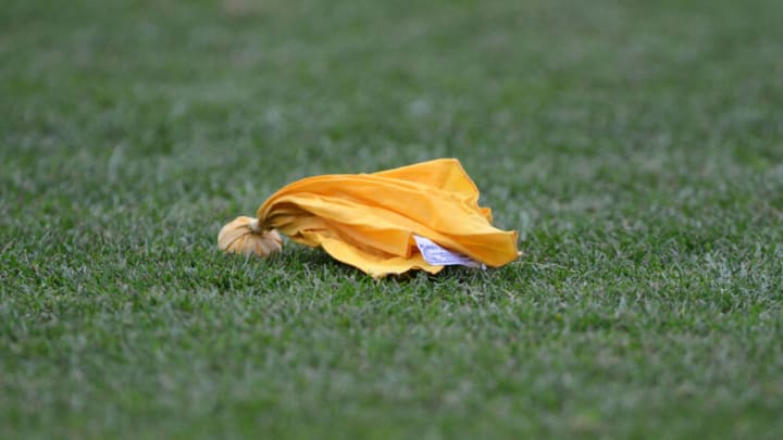 A detailed view of a referee's penalty flag laying on the field (Photo by Mark Cunningham/Getty Images)