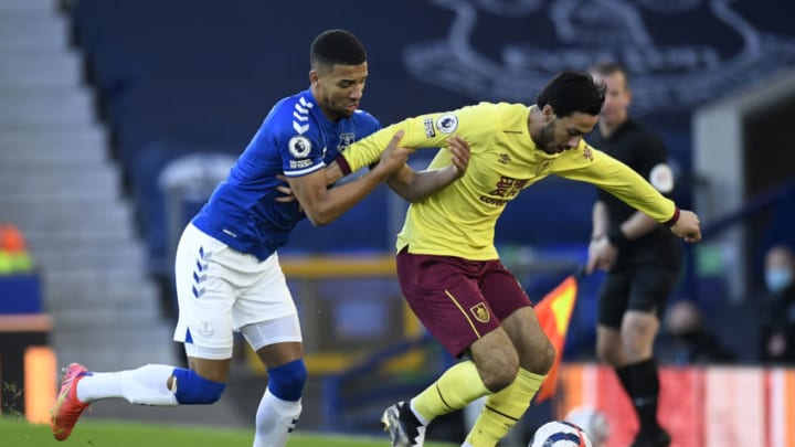 LIVERPOOL, ENGLAND - MARCH 13: Dwight McNeil of Burnley is challenged by Mason Holgate of Everton during the Premier League match between Everton and Burnley at Goodison Park on March 13, 2021 in Liverpool, England. Sporting stadiums around the UK remain under strict restrictions due to the Coronavirus Pandemic as Government social distancing laws prohibit fans inside venues resulting in games being played behind closed doors. (Photo by Peter Powell - Pool/Getty Images)