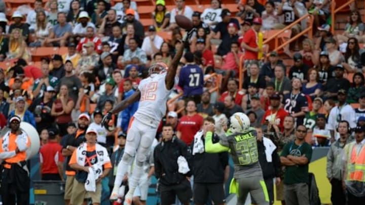 January 26, 2014; Honolulu, HI, USA; Team Rice wide receiver Josh Gordon of the Cleveland Browns (12) misses a catch against Team Sanders safety Eric Weddle of the San Diego Chargers (32) during the fourth quarter of the 2014 Pro Bowl at Aloha Stadium. Team Rice defeated Team Sanders 22-21. Mandatory Credit: Kyle Terada-USA TODAY Sports