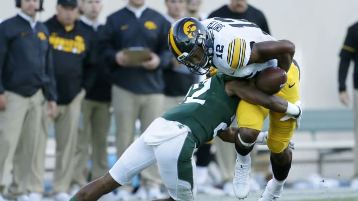 EAST LANSING, MI – SEPTEMBER 30: Wide receiver Brandon Smith #12 of the Iowa Hawkeyes fumbles the ball when hit by cornerback Josiah Scott #22 of the Michigan State Spartans during the second half at Spartan Stadium on September 30, 2017 in East Lansing, Michigan. Michigan State defeated Iowa 17-7. (Photo by Duane Burleson/Getty Images)