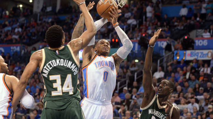 Apr 4, 2017; Oklahoma City, OK, USA; Oklahoma City Thunder guard Russell Westbrook (0) drives to the basket between Milwaukee Bucks forward Giannis Antetokounmpo (34) and guard Tony Snell (21) during the third quarter at Chesapeake Energy Arena. Mandatory Credit: Mark D. Smith-USA TODAY Sports