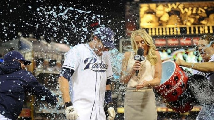 Jul 29, 2013; San Diego, CA, USA; San Diego Padres pinch hitter Chris Denorfia (13) is dumped with Powerade by catcher Nick Hundley (right) during a post-game interview with Fox Sports San Diego reporter Kelly Crull following a walk off two-run home run in the ninth inning inning against the Cincinnati Reds at Petco Park. . Mandatory Credit: Christopher Hanewinckel-USA TODAY Sports