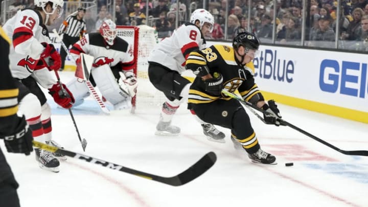 BOSTON - OCTOBER 12: Boston Bruins center Brad Marchand (63) controls the puck with pressure from New Jersey Devils defenseman Will Butcher (8) during the second period. The Boston Bruins host the New Jersey Devils in their home opener regular season NHL hockey game at TD Garden in Boston on Oct. 12, 2019. (Photo by Matthew J. Lee/The Boston Globe via Getty Images)