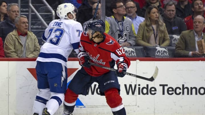 WASHINGTON, DC - MARCH 20: Washington Capitals left wing Carl Hagelin (62) hits Tampa Bay Lightning left wing Adam Erne (73) in the first period as former University of Maryland basketball coach Gary Williams watches on March 20, 2019, at the Capital One Arena in Washington, D.C. (Photo by Mark Goldman/Icon Sportswire via Getty Images)