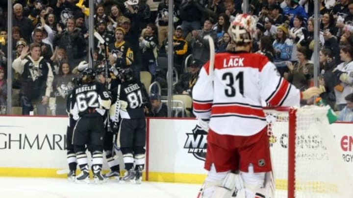 Jan 17, 2016; Pittsburgh, PA, USA; The Pittsburgh Penguins celebrate a goal by Pittsburgh Penguins defenseman Olli Maatta (hidden) as Carolina Hurricanes goalie Eddie Lack (31) reacts during the first period at the CONSOL Energy Center. Mandatory Credit: Charles LeClaire-USA TODAY Sports