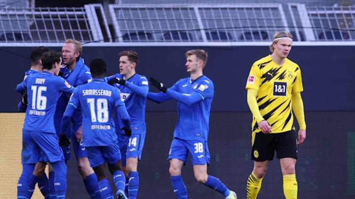 DORTMUND, GERMANY - FEBRUARY 13: Erling Haaland of Borussia Dortmund reacts as Ihlas Bebou (Hidden) of TSG 1899 Hoffenheim celebrates with team mates after scoring their side's second goal during the Bundesliga match between Borussia Dortmund and TSG Hoffenheim at Signal Iduna Park on February 13, 2021 in Dortmund, Germany. Sporting stadiums around Germany remain under strict restrictions due to the Coronavirus Pandemic as Government social distancing laws prohibit fans inside venues resulting in games being played behind closed doors. (Photo by Lars Baron/Getty Images)
