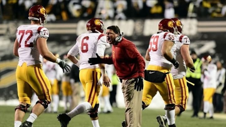 Nov 23, 2013; Boulder, CO, USA; Southern California Trojans interim head coach Ed Orgeron congratulates offensive tackle Chad Wheeler (72) and quarterback Cody Kessler (6) and guard John Martinez (59) and and offensive tackle Kevin Graf (77) after a touchdown drive in the second quarter against the Colorado Buffaloes at Folsom Field. Mandatory Credit: Ron Chenoy-USA TODAY Sports