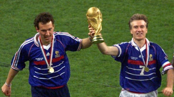 French captain Didier Deschamps (C) and Laurent Blanc (L) hold the FIFA trophy after the 1998 Soccer World Cup final between Brazil and France at Stade de France in Saint-Denis, near to Paris. France won 0-3. (ELECTRONIC IMAGE) AFP PHOTO THOMAS COEX (Photo credit should read THOMAS COEX/AFP/Getty Images)