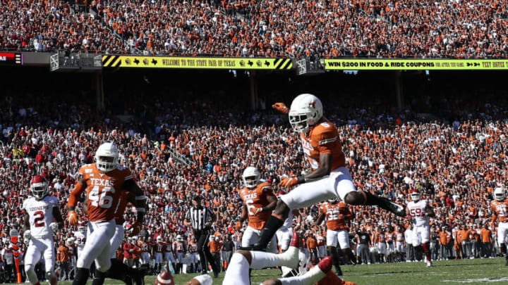 DALLAS, TEXAS - OCTOBER 12: D'Shawn Jamison #5 of the Texas Longhorns jumps over Jalen Hurts #1 of the Oklahoma Sooners in the second quarter during the 2019 AT&T Red River Showdown at Cotton Bowl on October 12, 2019 in Dallas, Texas. (Photo by Ronald Martinez/Getty Images)