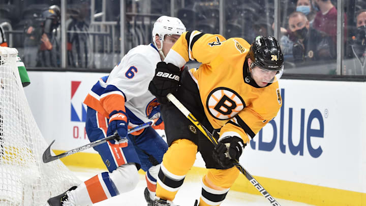 Apr 15, 2021; Boston, Massachusetts, USA; Boston Bruins left wing Jake DBrusk (74) tries to gain control of the puck in front of New York Islanders defenseman Ryan Pulock (6) during the second period at TD Garden. Mandatory Credit: Bob DeChiara-USA TODAY Sports