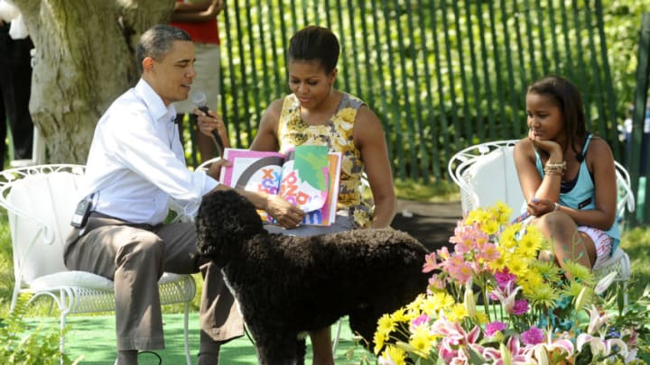 WASHINGTON, DC - APRIL 25: (AFP-OUT) President Barack Obama and first lady Michelle Obama read "Chicka Chicka Boom Boom" to children during the White House Easter Egg Roll as Sasha Obama listens and dog Bo tries to get attention on the South Lawn of the White House on April 25, 2011 in Washington, DC. About 30,000 people are expected to attend the 133-year-old tradition of rolling colored eggs down the White House lawn. (Photo by Roger L. Wollenberg-Pool/Getty Images)