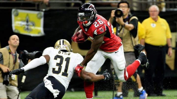 Sep 26, 2016; New Orleans, LA, USA; Atlanta Falcons running back Tevin Coleman (26) breaks a tackle attempt by New Orleans Saints free safety Jairus Byrd (31) during the third quarter of a game at the Mercedes-Benz Superdome. Mandatory Credit: Derick E. Hingle-USA TODAY Sports